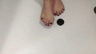 Two tiny feet smashing two tiny donuts