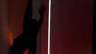 The gymnast dances at the pole arching very erotically.